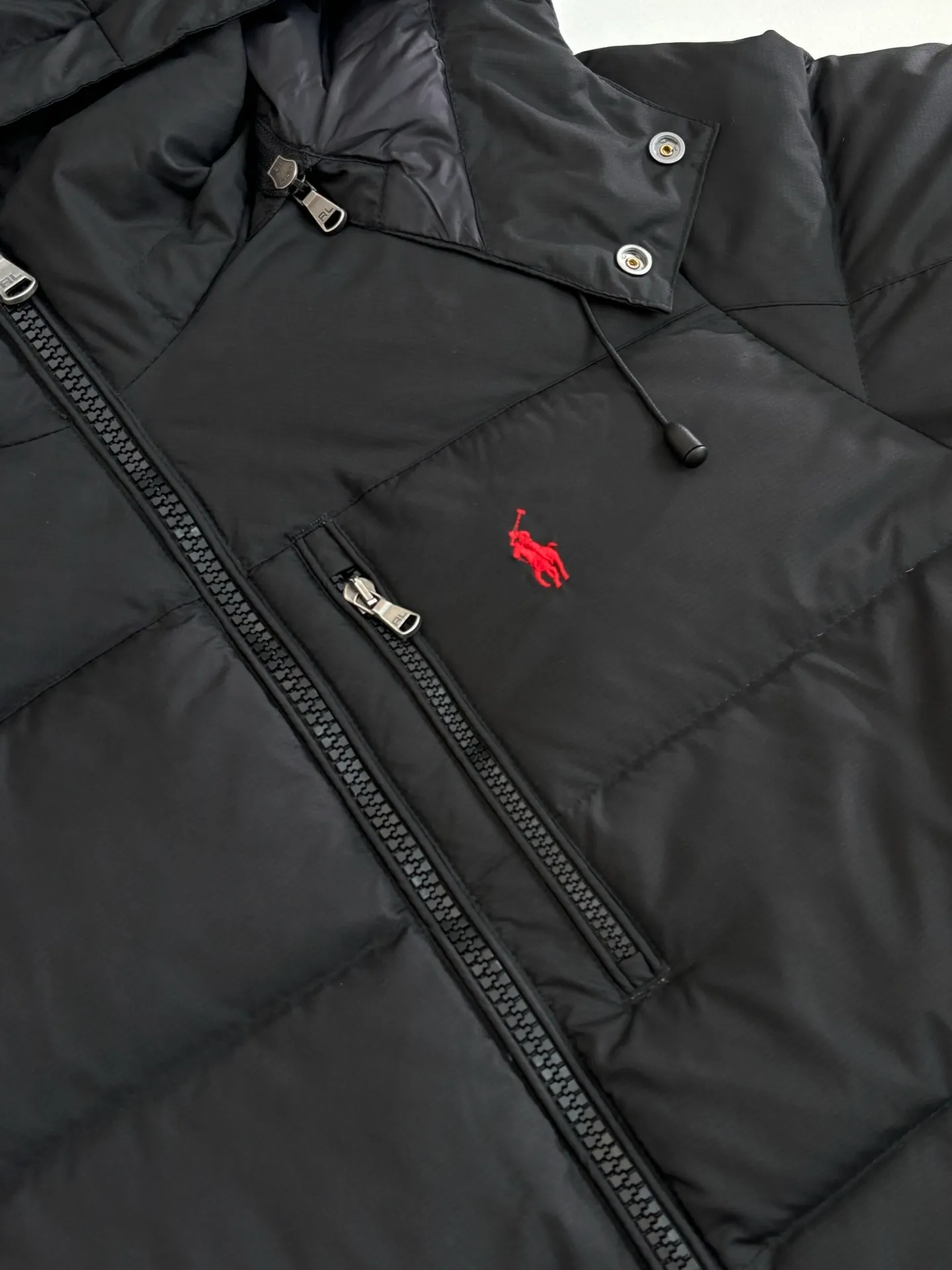 P970 Rah Laure*/Ralph Lauren solid color classic red label pony embroidered hooded down jacket. The nylon fabric has good windproof and waterproof properties, which can effectively block the intrusion of wind and rain from the outside and keep the interior dry. It is suitable for wearing in humid or rainy environments. The chest label uses an imported MEO embroidery machine. It first scans the original pattern and then uses high-quality silk thread to make a pattern. The density effect is adjusted by continuous pattern making. Detachable: Equipped with detachable nylon, users can easily disassemble or install it according to weather changes or personal preferences, which is both practical and convenient. Exquisite details: the zipper design is simple and elegant, easy to operate; the closing design of the cuffs and hem effectively prevents the intrusion of cold wind, improving the warmth and comfort of wearing. It uses 90 white duck down with a weight of 260g to ensure excellent thermal insulation performance. After strict screening and processing, the velvet is not easy to get drilled, ensuring durability. The overall wiring is straight and delicate, the fabric is comfortable and soft, and the color is consistent without color difference. It can be matched with the same style to create a fashionable look and control various occasions. Customized accessories, complete with three standards, same style for men and women!  Size: S/M/L/XL/XXL